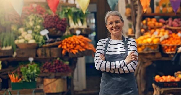 cheerful small business owner posing at farmers market, wearing apron looking at camera (1). - farmer selling produce stock pictures, royalty-free photos & images